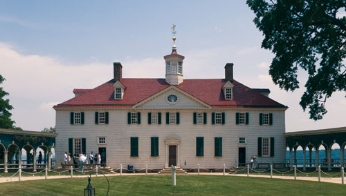 A large white house with a red roof and white trim.