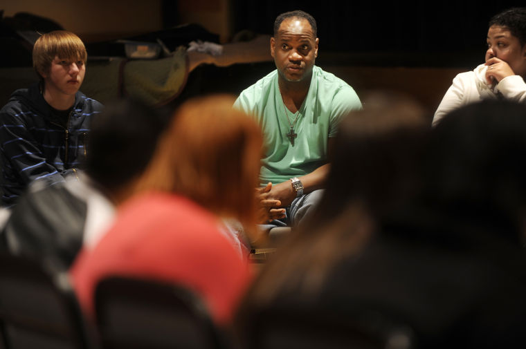 A group of people sitting in a circle talking to one another.