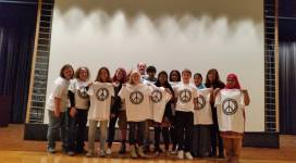 A group of people holding t - shirts with peace signs on them.
