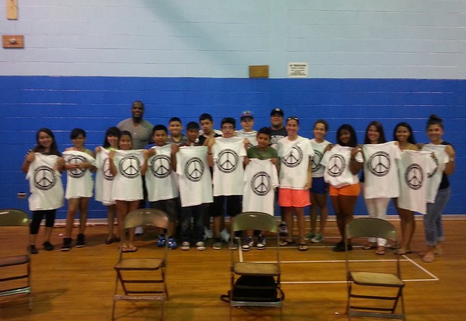 A group of people holding t - shirts in a gym.