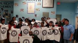 A group of people holding up black history month t - shirts.