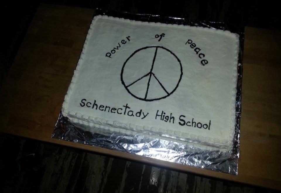 A white cake with a peace sign on it.