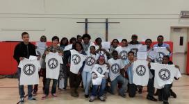 A group of people holding t - shirts with peace signs on them.