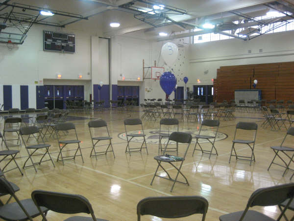 A gymnasium filled with chairs and balloons.