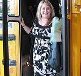 A woman is getting out of a school bus.