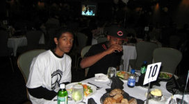 Two young men sitting at a table at a banquet.