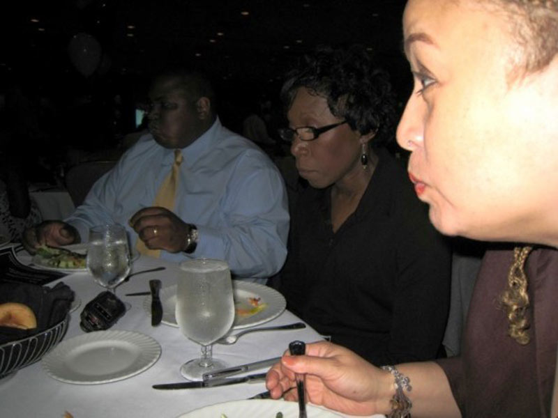 A woman sitting at a table with a plate of food.