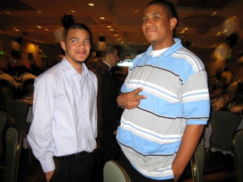 Two young men standing next to each other at a banquet.
