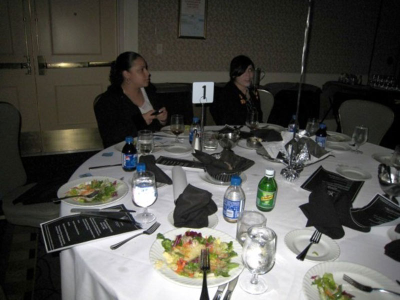 Two women sitting at a table at a banquet.