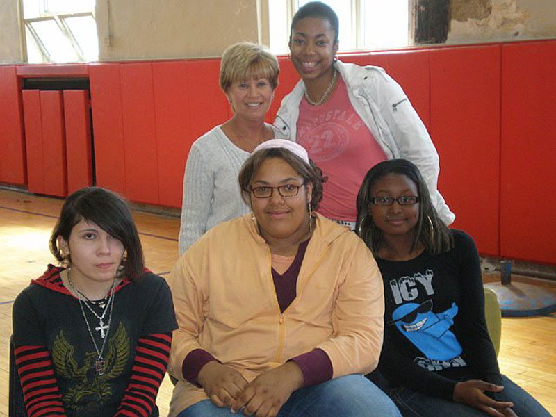 A group of girls posing for a picture in a gym.