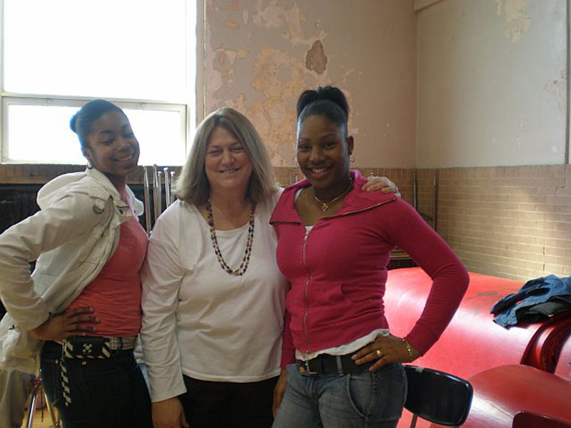 Three women posing for a picture in a room.