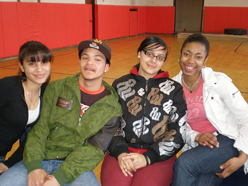 Four young people posing for a picture in a gym.
