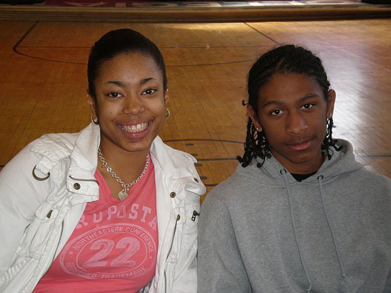 A girl and a boy posing for a picture in a gym.