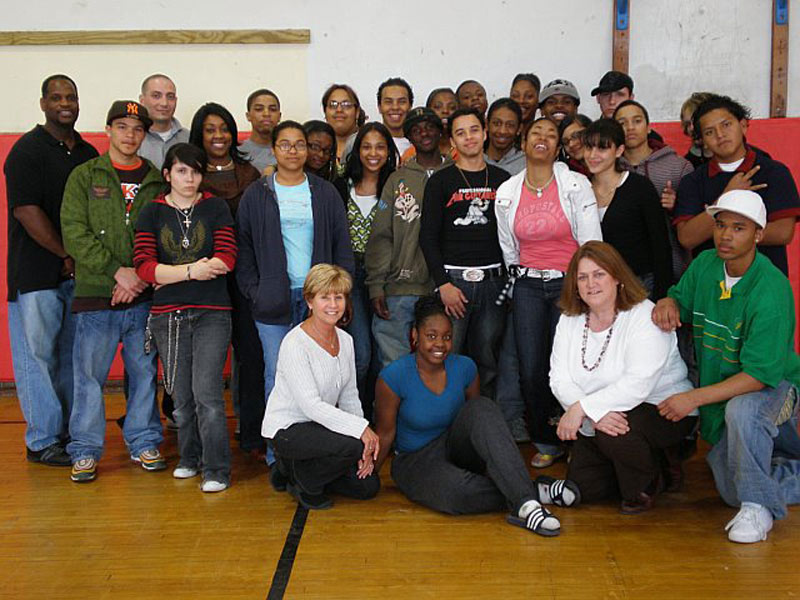 A group of people posing for a picture in a gym.