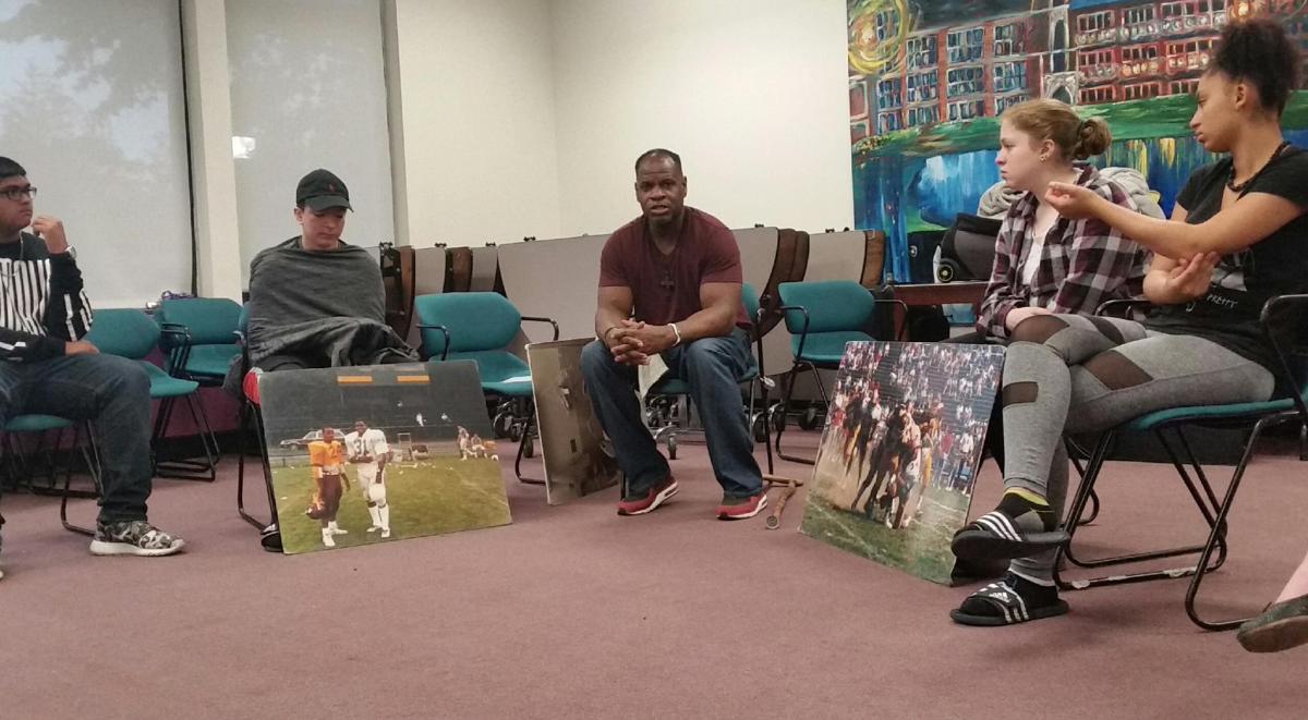 A group of people sitting in a room with pictures.
