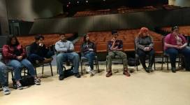 A group of people sitting in chairs in an auditorium.