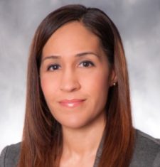 A woman in a business suit is posing for a photo.